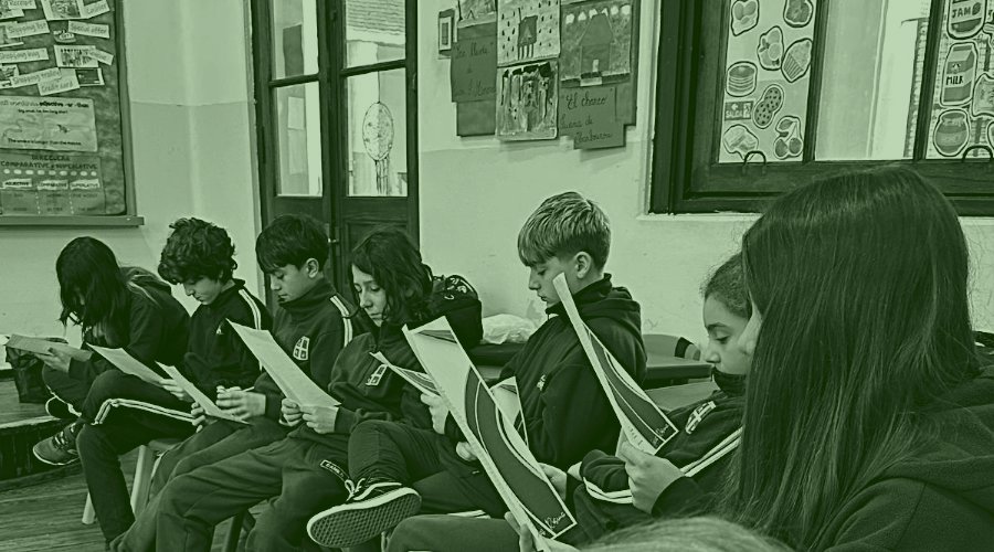 Un grupo de alumnos leyendo un repartido, en silencio, en el salón de clase.